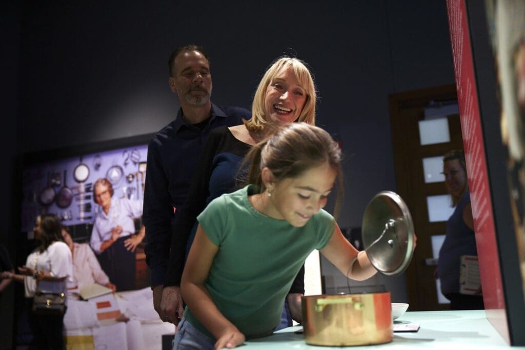 Family enjoying a the sensory cooking experience at the Julia Child: A Recipe for Life exhibition