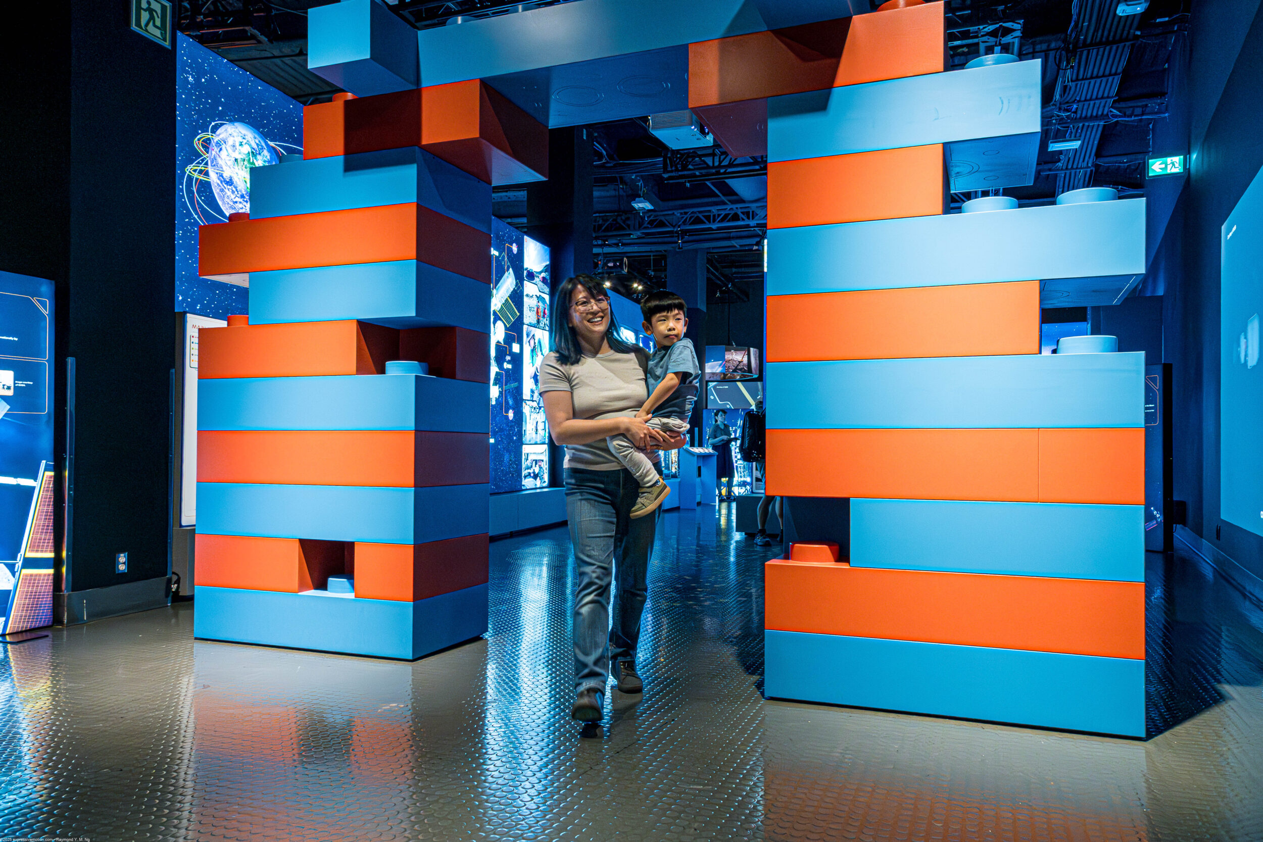 Woman and child in entering the colorful Artemis Adventure Exhibition